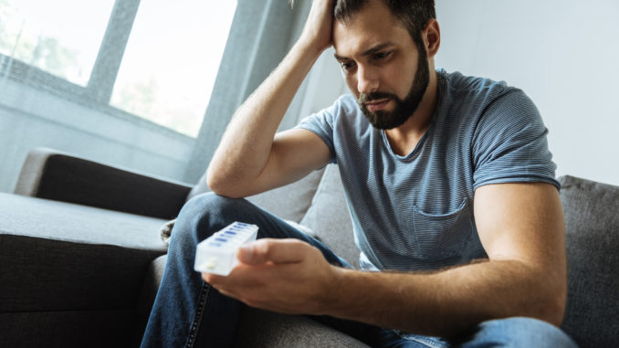 man holding a pill organizer