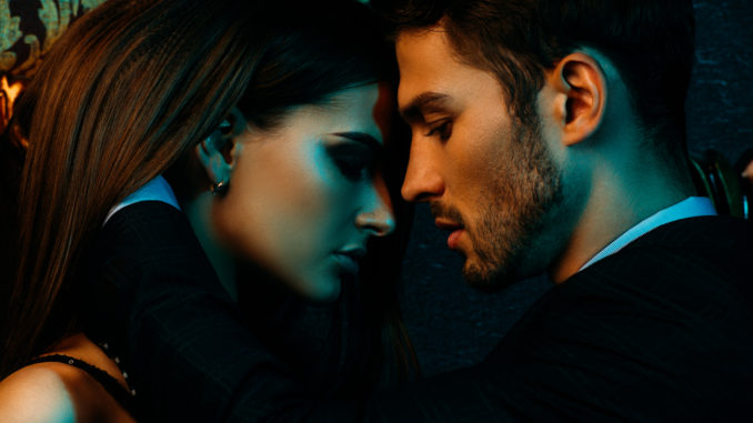 Close-up portrait of a passionate couple in elegant evening dresses.