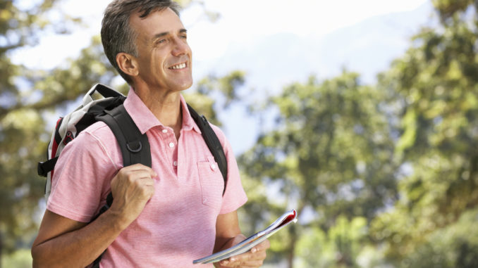 Middle Aged Man Hiking Through Countryside