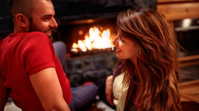 Young couple in love at home front of fireplace