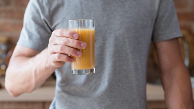 unrecognizable man holding a glass with a drink.