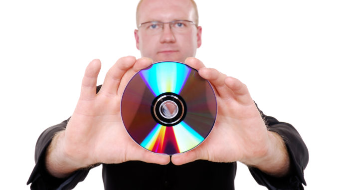 A man holding a CD on an isolated white background.