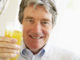 Senior Man Smiling At Camera And Drinking Orange Juice