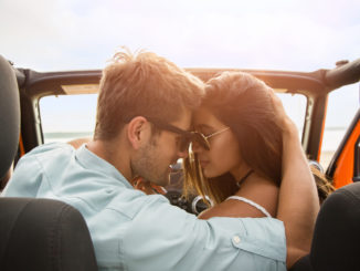 Beautiful couple in love embracing while sitting in a car