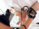 Female hands in police gloves puts handcuffs on man`s hands.