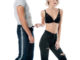 cropped view of woman in bra playfully touching man jeans on white