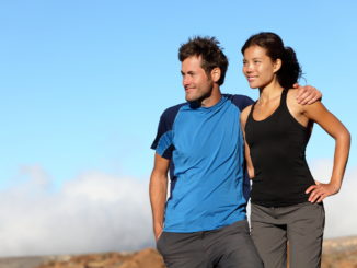 Happy multiracial couple looking outdoors. Sporty healthy young interracial couple looking at blue sky smiling. Asian woman and man.