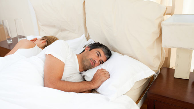 Sad couple lying in the bed after having an argument