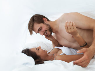 Intimate young couple in bedroom enjoying each other
