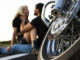 Bikers man and woman stopped at the side of the road to rest and kiss passionately.