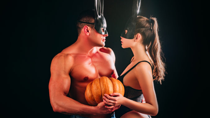 Halloween sensual couple. models each other with Pumpkin in halloween bunny mask. Design for banner. Boyfriend and girlfriend gently touch, fashion men and woman, boy girl young lovers