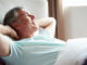 Middle Aged Man Waking Up In Bed Looking Away From Camera Smiling