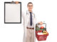 Young doctor holding a shopping basket full of groceries and a clipboard isolated on white background