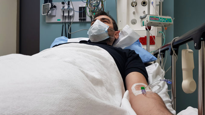 Young man lying in hospital bed.