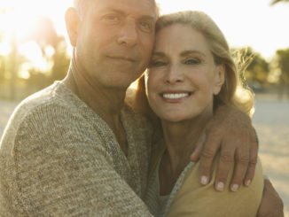 Closeup portrait of happy senior couple embracing on tropical beach