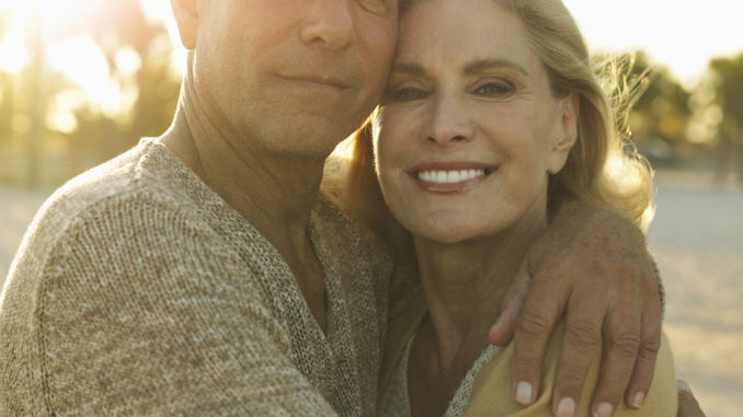 Closeup portrait of happy senior couple embracing on tropical beach