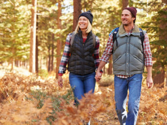 Couple holding hands walking in a forest