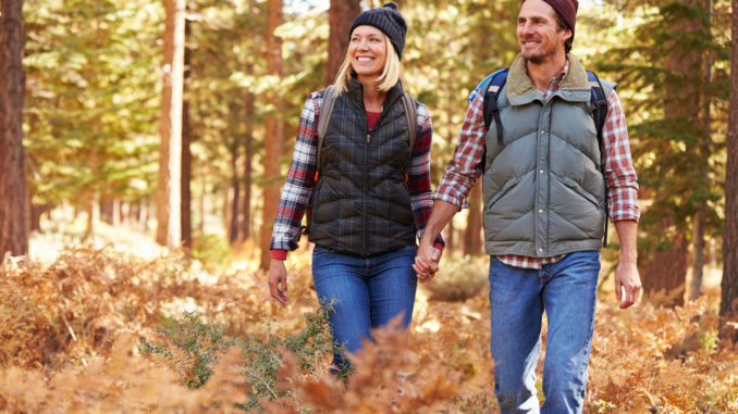 Couple holding hands walking in a forest