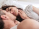 Young women lying on bed with man. Romantic young couple on bed.