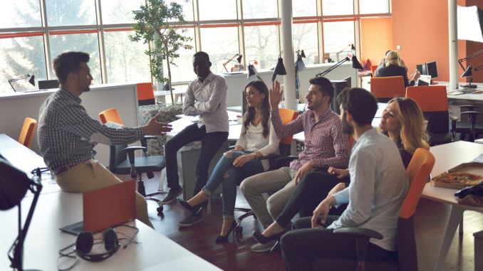 Young people group in modern office have team meeting and brainstorming while working on laptop and drinking coffee.