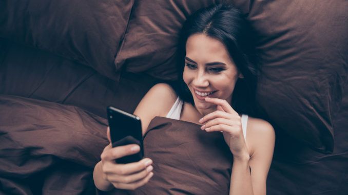 Top above high angle view close-up portrait of her she nice attractive, lovely flirt charming cute cheerful cheery girl using gadget sending photos lying in bed in room flat house indoors