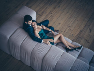 High angle above view photo of two style stylish trendy classy people, couple rich guy and lady lying close on comfy couch night club party look wear formalwear suit short shiny dress loft indoors