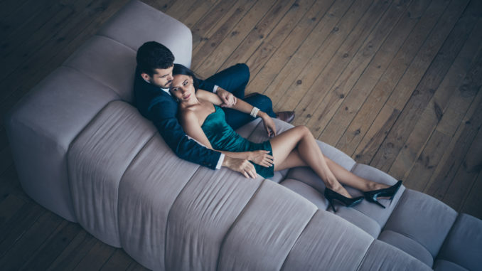 High angle above view photo of two style stylish trendy classy people, couple rich guy and lady lying close on comfy couch night club party look wear formalwear suit short shiny dress loft indoors