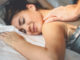 Happy couple having tender moments in the bed - Young romantic lovers intimate massaging and cuddling in the bedroom - People love relationship and relax wellness treatment concept