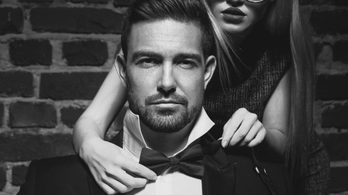 Woman tie bow for man in tuxedo black and white