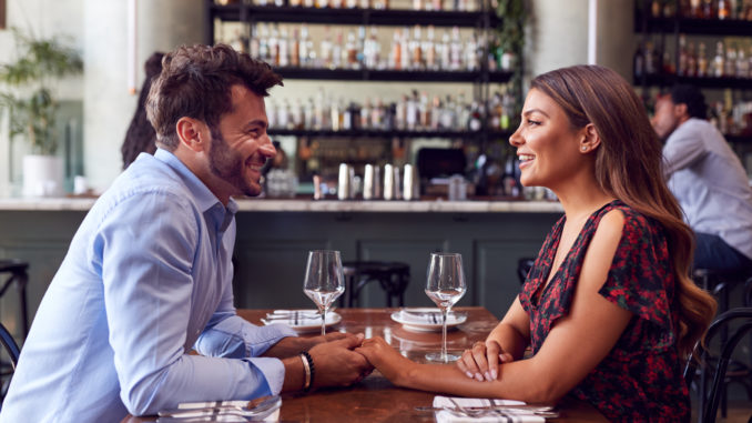 Couple On Valentines Day First Date Sitting At Table In Restaurant