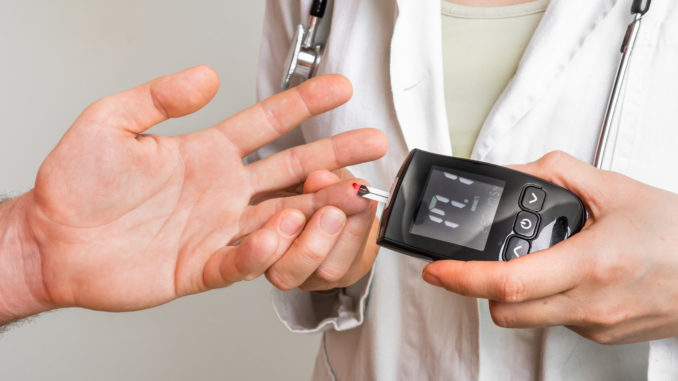 Doctor checking blood sugar level with glucometer