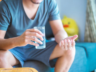 Man sitting and hold glass of water.