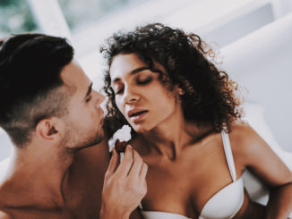 Happy Romantic Couple Eating Strawberrys in Bed