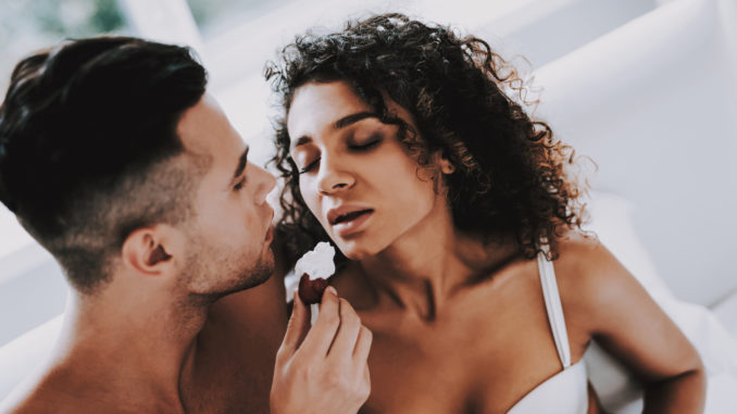 Happy Romantic Couple Eating Strawberrys in Bed