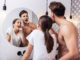 Man hugging. Man with no shirt on his body hugging his lovely wife while brushing teeth together