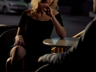 Attractive blond female seducing man on restaurant terrace, escort service