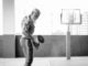 Senior fitness man doing biceps curl exercises inside old gym