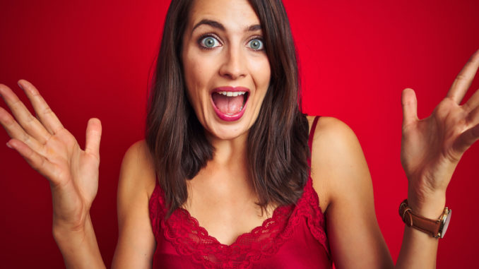 Young beautiful woman wearing lingerie over red isolated background celebrating crazy and amazed for success with arms raised and open eyes screaming excited.