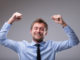 Jubilant happy man cheering and punching the air with his fists as he celebrates a victory or success