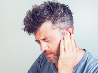 Man with earache is holding his aching ear body pain concept