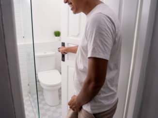 Man hold his genitals to pee and open the toilet door