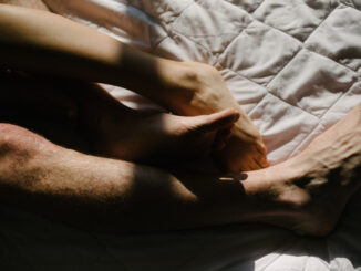 Feet of man and woman in bed in the morning close-up