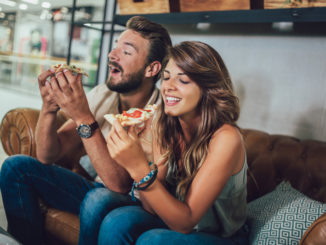 Shot of a young happy couple eating pizza in a restaurant