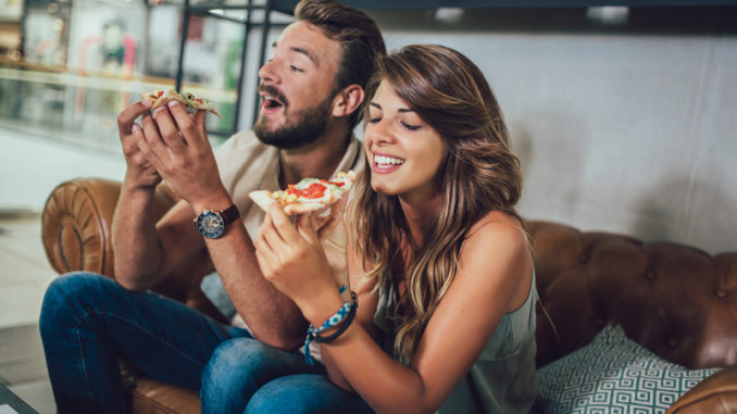 Shot of a young happy couple eating pizza in a restaurant