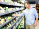 Handsome man doing grocery shopping at the supermarket