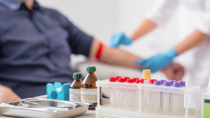 Doctor preparing patient for blood sampling