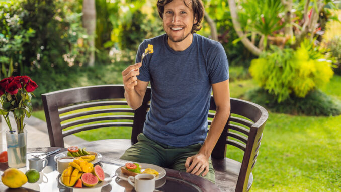 A man is having breakfast on the terrace.