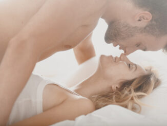 Romantic photo of pair kissing and caressing in bed