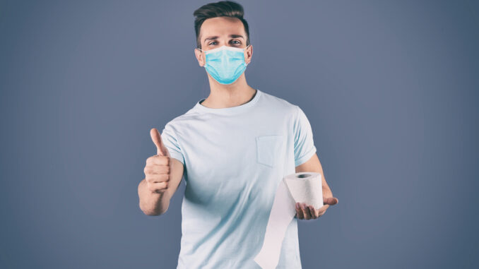 dreamstime_s_186019051 Man in medical mask holding toilet paper roll