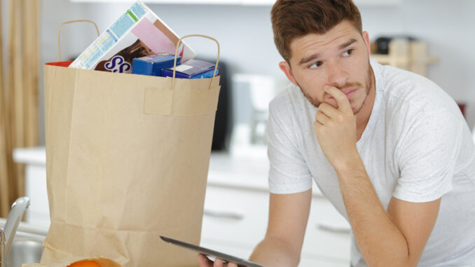 Man after grocery shopping using a digital touch screen tablet